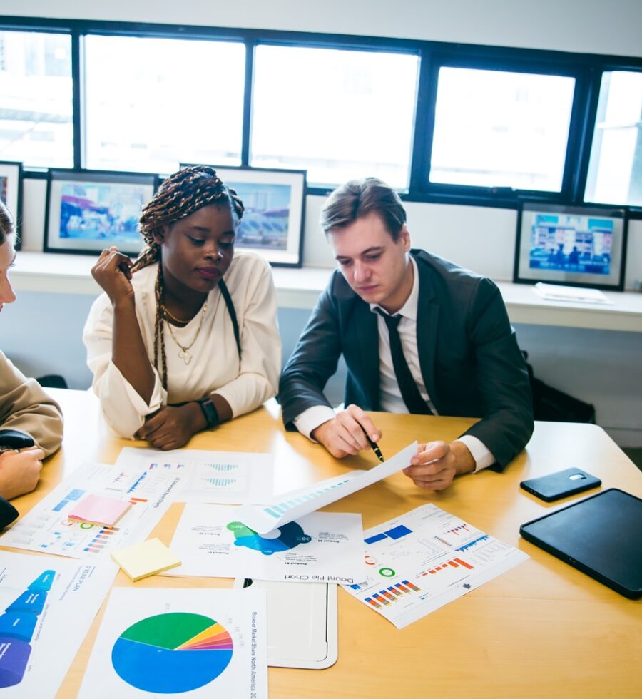 business team meeting with stats and review graphs of company target, goals or market research with data analysis. Above, table or paperwork report of growth, progress or startup performance analytics